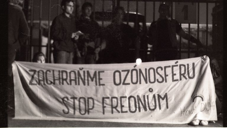 Černobílá stará fotografie, lidé drží nápis Zachraňme ozonosféru, stop freonům.
